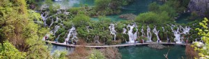 Water path in Plitvice park, Croatia with beautiful waterfall behind it
